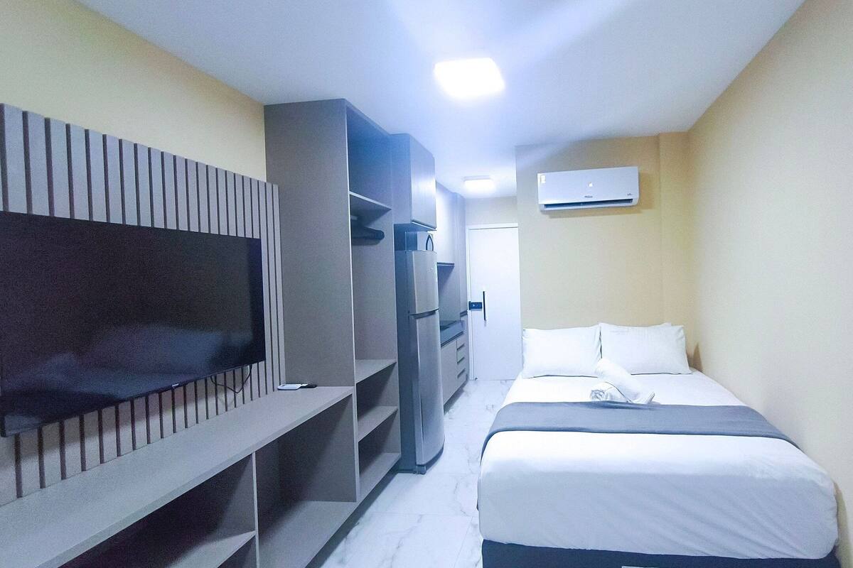 Une chambre d’hôtel équipée d’un lit, d’une télévision, d’une armoire et d’un appareil de climatisation.