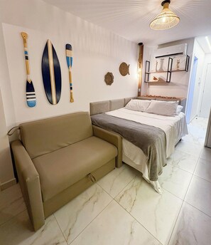 Une chambre à coucher comprenant un lit, un canapé et des éléments de décoration murale.