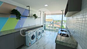 Eine moderne Küche mit Waschmaschine, Spüle und Blick auf die Stadt.