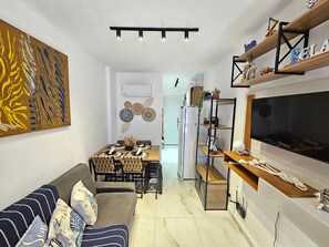 Un espace de vie moderne comprenant un coin repas, un canapé et un téléviseur.