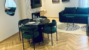 En moderne stue med spiseplads, sofa og kunst på væggene.
