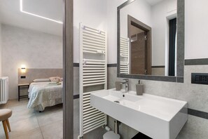 A modern bathroom with a white sink, mirror, and towel rack. - Double Room - MyAostaProject with Mountain View, Wi-Fi and Air Conditioning (Aosta)