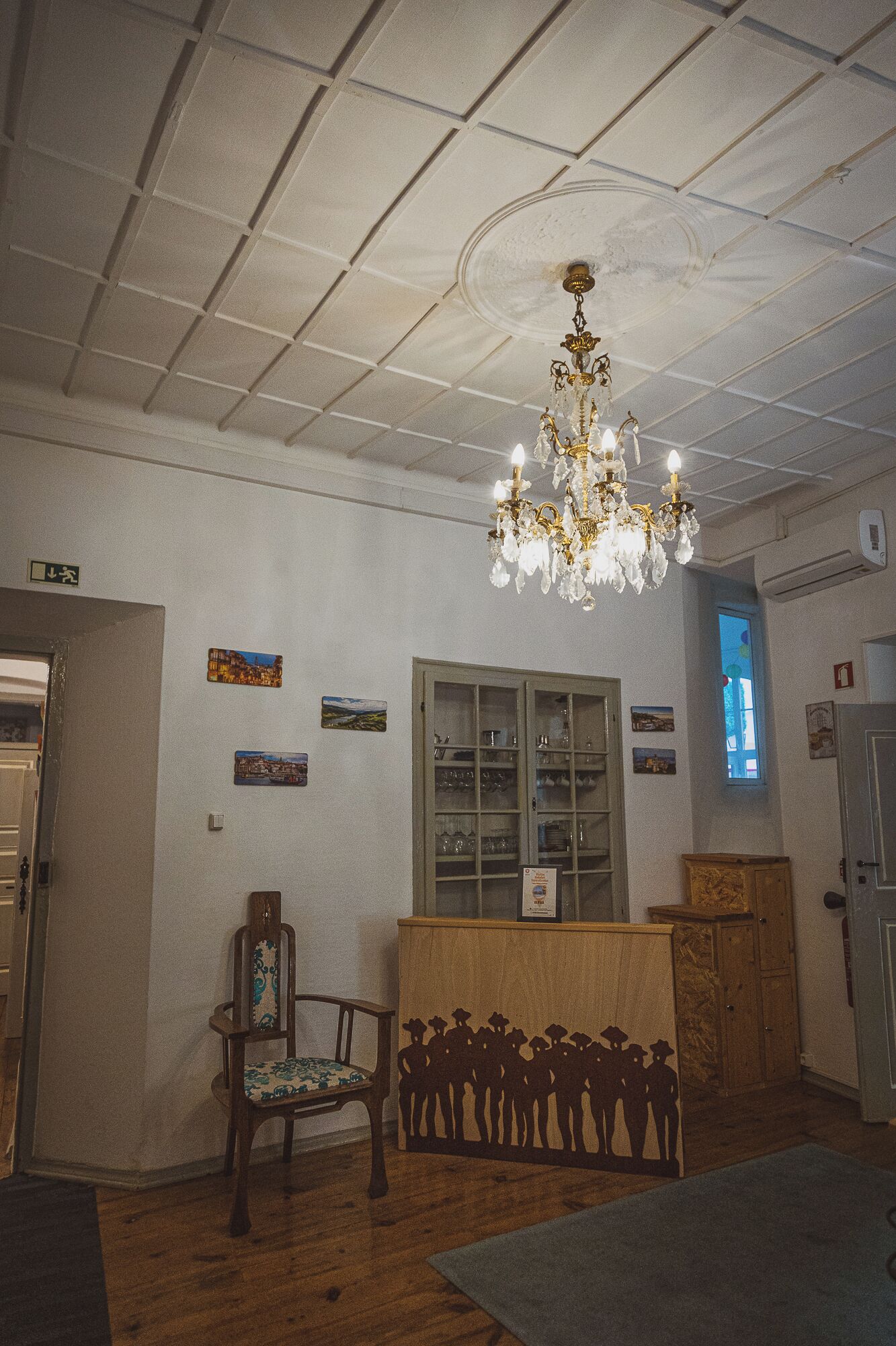 Una habitación con candelabro, muebles de madera y adornos en la pared.
