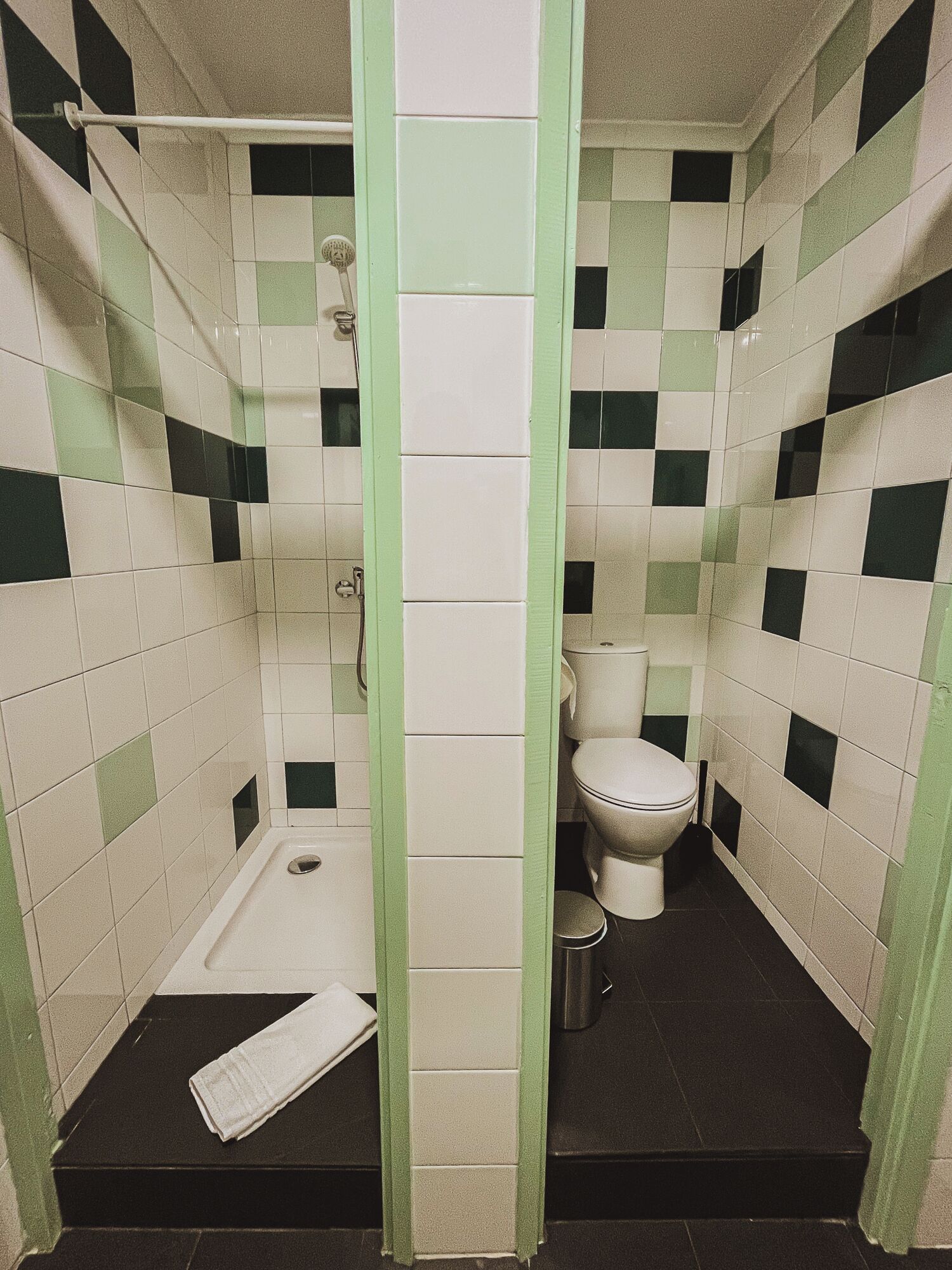 A small bathroom with a toilet, a shower, and a sink.