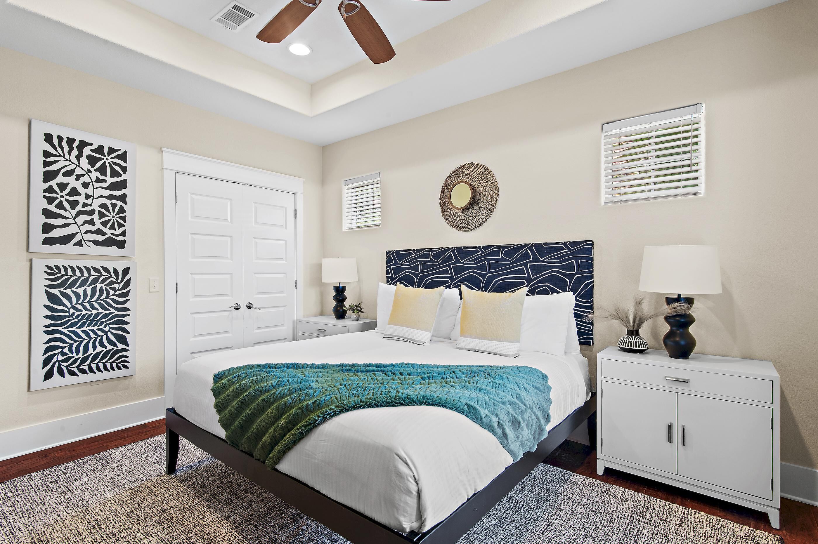 Une chambre à coucher comprenant un lit, des tables de chevet, une commode et des éléments décoratifs muraux.