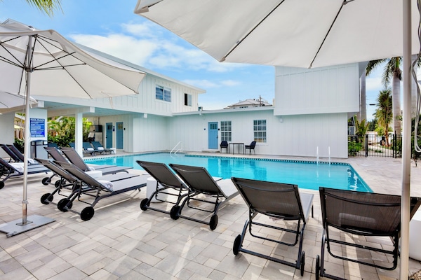 Een buitenzwembad, parasols voor strand/zwembad