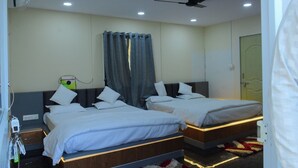 Une chambre d’hôtel avec deux lits, un ventilateur de plafond et une fenêtre avec des rideaux.