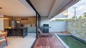 A modern kitchen with a central island, a dining area with wooden chairs, a barbecue grill, and a swimming pool. - House w/ Pool and Barbecue Grill Sgt0000 (Porto de Pedras)