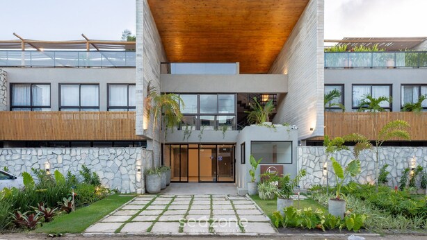 A modern building with a stone facade, wooden accents, and a central entrance with glass doors. - House w/ Pool and Barbecue Grill Sgt0000 (Porto de Pedras)