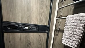 Eine Holztür mit Bedienfeld, einem Handtuchhalter mit Handtuch und einem Metallgriff.