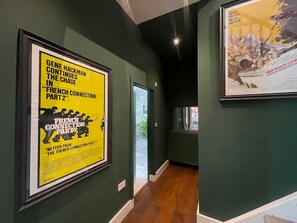 A hallway with green walls and framed posters.