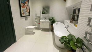 Une salle de bain moderne équipée de toilettes, d’un lavabo et d’une baignoire.