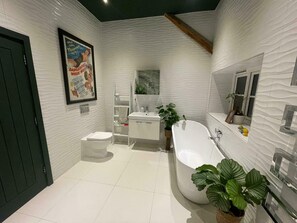 Een moderne badkamer met toilet, wastafel en bad.