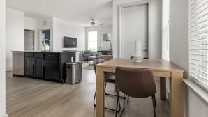 Una cocina moderna con comedor, ventilador de techo y vistas al exterior a través de la ventana.