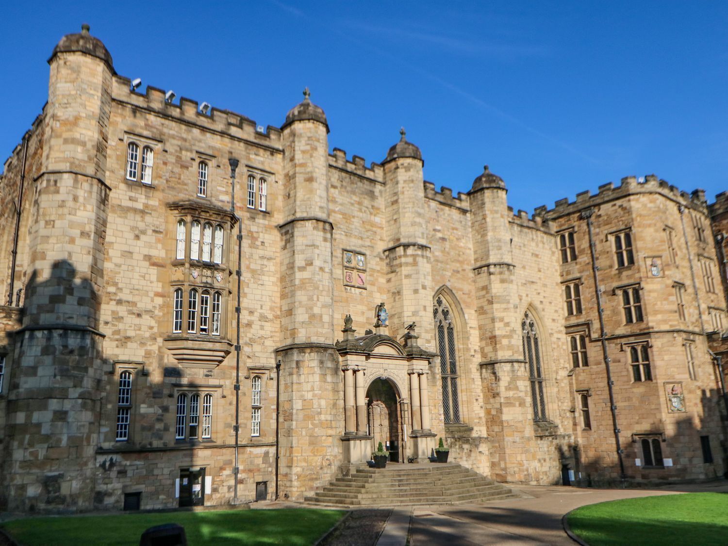 A large stone building with a central entrance, multiple windows, and a symmetrical facade.