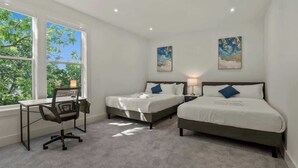 Ein Schlafzimmer mit zwei Betten, einem Schreibtisch und einem Stuhl.