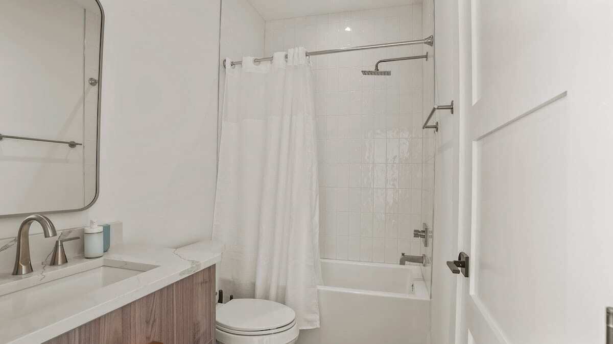 A modern bathroom with a sink, toilet, and shower area.