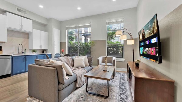 Ein modernes Wohnzimmer mit Sofa, Couchtisch und Fernseher.