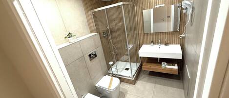 A modern bathroom with a glass-enclosed shower, a bidet, a toilet, and a sink with a mirror above.