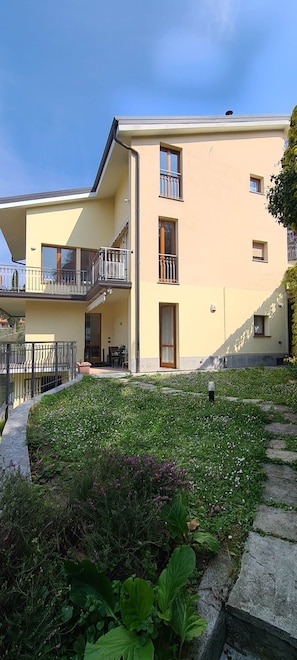 Un immeuble de deux étages doté de balcons, d’un jardin et surplombant un ciel dégagé.
