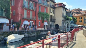 Un paseo a orillas de un canal con barcos, una heladería y una tienda Riva Gel.