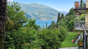 Un edificio residencial con balcón que da a un paisaje montañoso y un lago.