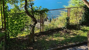Un sendero de piedra que conduce a un área cercada con vista a un lago y montañas.