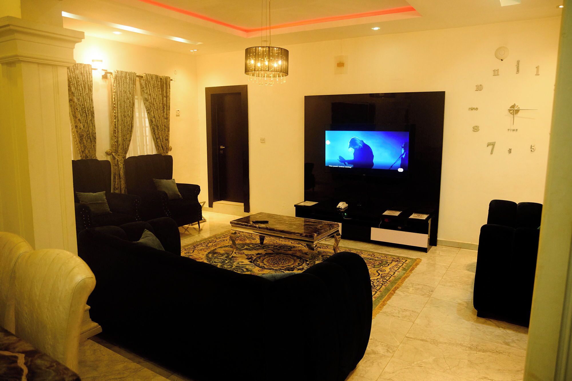 A living room with a sofa, a coffee table, and a television.