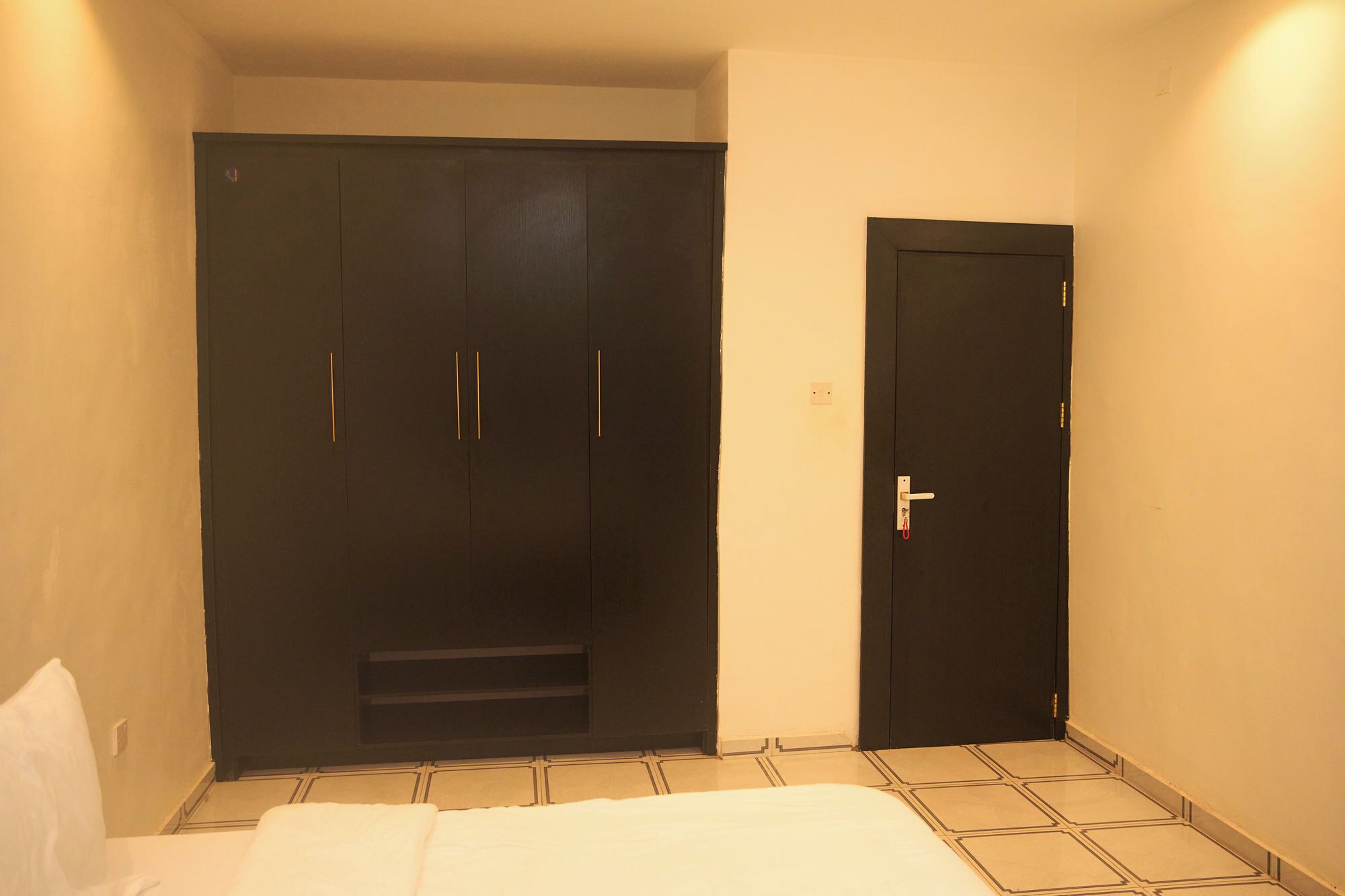 Une chambre à coucher avec un lit, une armoire et une porte.
