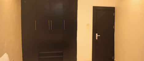 Une chambre à coucher avec un lit, une armoire et une porte.