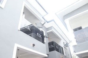 Een modern gebouw met balkons en een opvallend logo op de gevel.
