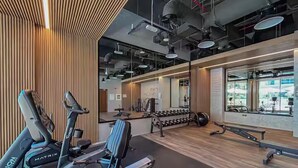Ein modernes Fitnessstudio mit Fahrrädern, Hanteln und einer Trainingsbank.