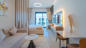 Ein modernes Hotelzimmer mit einem großen Bett, einer Couch, einem Essbereich und Blick auf die Stadt.