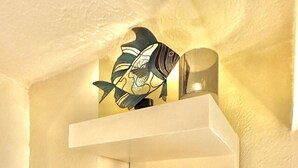 A white shelf with a decorative fish, a glass vase, and a small plant. - Tropic Retreat in the heart of The City (Mansfield)