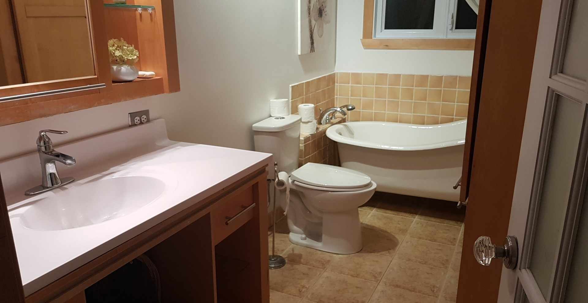 Et badeværelse med vask, toilet og badekar.
