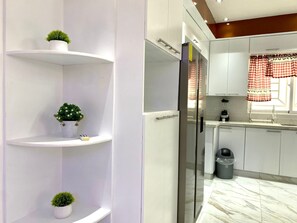 A modern kitchen with white cabinets, a stainless steel refrigerator, and a marble floor. - Luxurious home with private pool for vacationing in La Romana (La Romana)