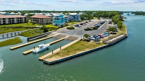 A marina with docked boats, a parking lot, and buildings with a waterfront view. - Island Sunrise Town Home 3 Bdrm/2.5 Bath Sleeps 12!   7 Min walk to the Beach! (Carolina Beach)