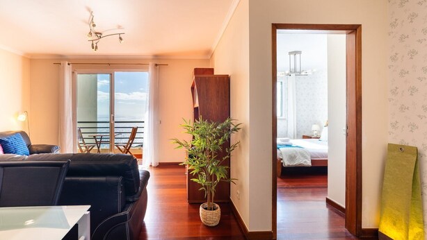 Ein modernes Hotelzimmer mit Balkon, Essbereich und Meerblick.