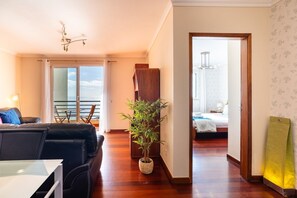 Une chambre d’hôtel moderne avec balcon, un coin repas et vue sur la mer.