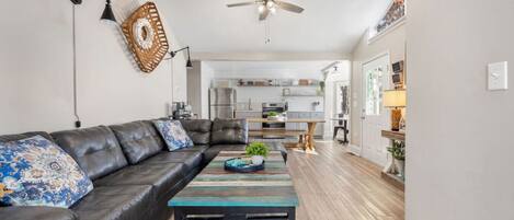 A modern living room with a leather sofa, a wooden coffee table, and a ceiling fan.