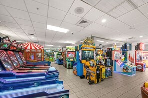 Eine Indoor-Spielhalle mit verschiedenen Spielautomaten, darunter eine Kegelbahn und ein Spiel im Transformer-Design.