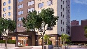 Un hotel moderno con una cafetería en la planta baja, un espacio exterior bien cuidado y una vista despejada de la calle.