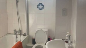 A bathroom with a bathtub, toilet, and sink. - Colorful 1 bedroom Flat in South East London area (Bromley)