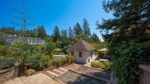 A residential property with a small house, a wooden deck, and a swimming pool.