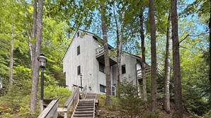 A wooden staircase leading to a building surrounded by trees. - Waterville Estate chalet perfect for relaxing stays Access to Pool, Hot Tub, Gym (Campton)