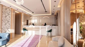 Un área de recepción moderna con pared de mármol, detalles de madera y un mostrador con dos sillas.