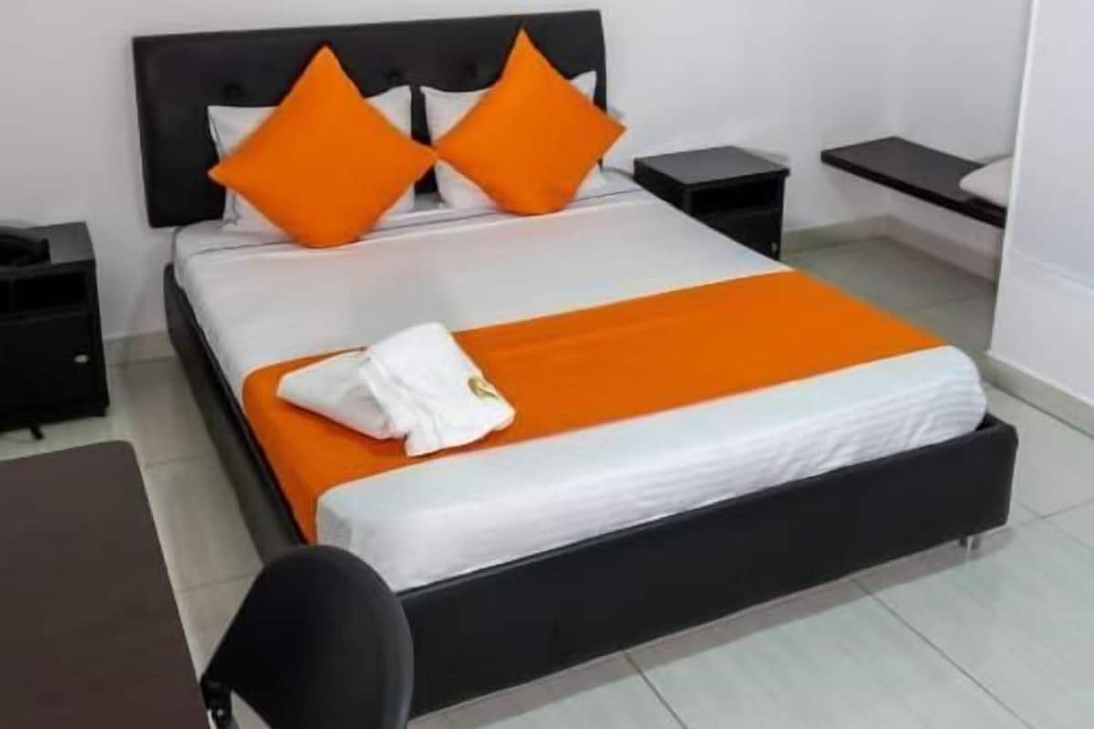 Ein Hotelzimmer mit Bett, Nachttisch, Stuhl und Schreibtisch.