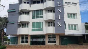 Un hôtel à plusieurs étages, dont la façade est ornée d’une grande enseigne indiquant « HÔTEL FENIX ».