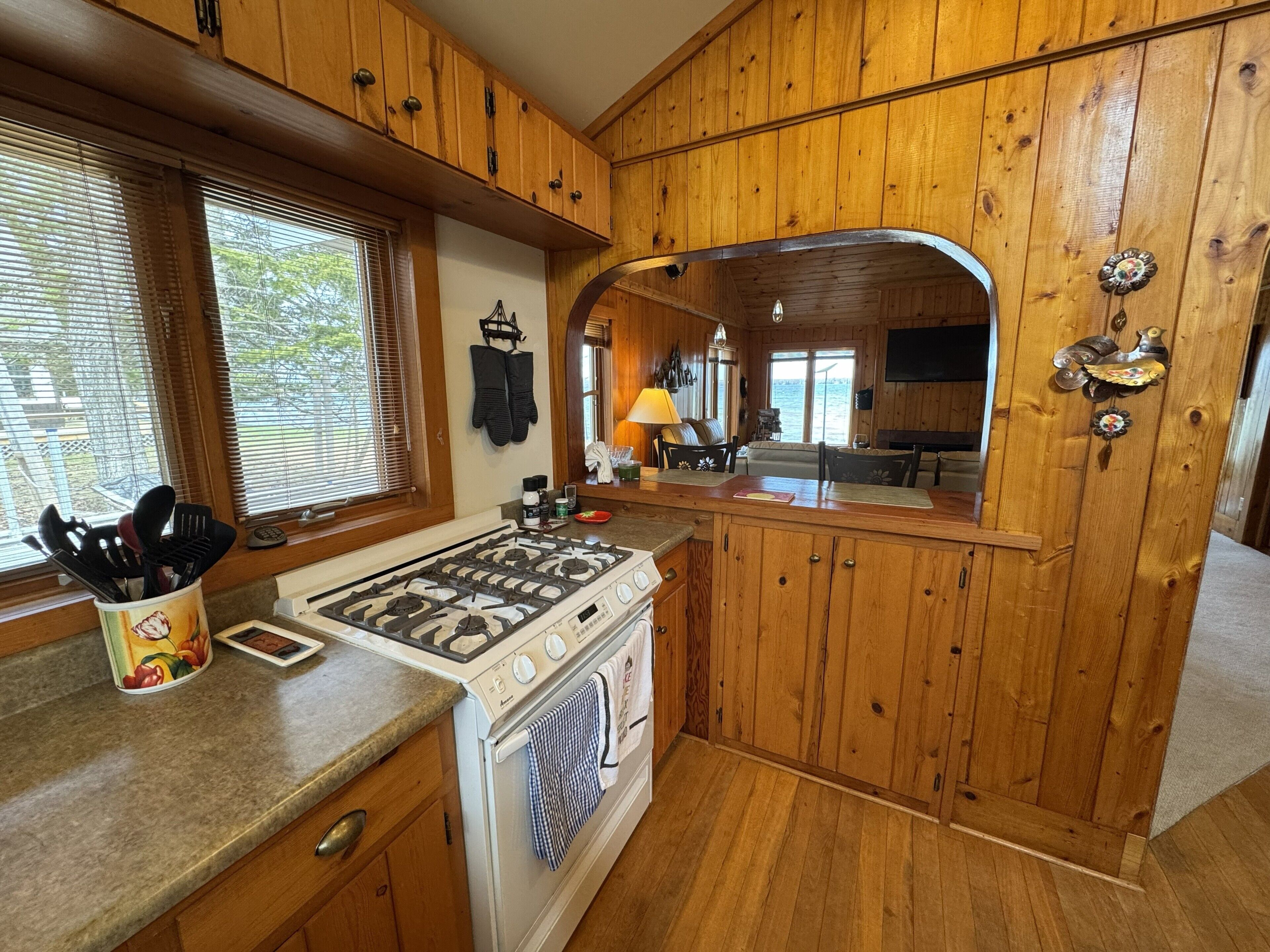 Une cuisine de style rustique, avec des murs en bois, un poêle, un four et des armoires en bois.