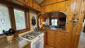 Una cucina in stile baita in legno, con piano cottura, forno e mobili impiallacciati.